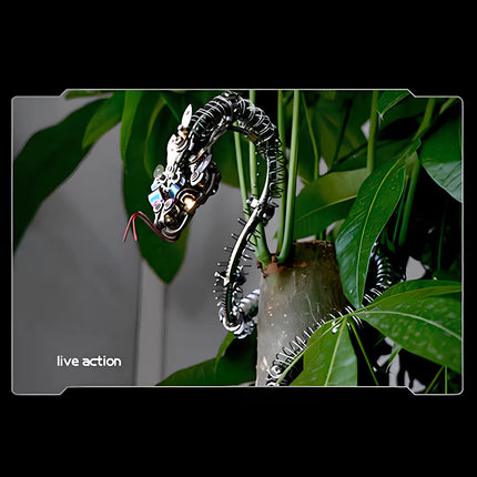 Live action display of a striking metallic 3D puzzle dragon/snake model climbing a plant, showcasing a unique maquette en métal.