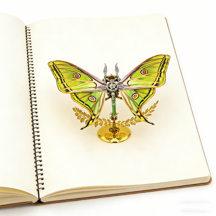 A beautifully crafted steampunk puzzle, a vibrant mechanical Luna moth with striking green and yellow wings, delicately placed on a blank spiral-bound notebook. This exquisite metal model is a testament to mechanical steampunk artistry, serving as an inspiring decorative piece or a rewarding 3D puzzle Metal Kit for creative individuals, a truly unique steampunk mech that sparks ideas.