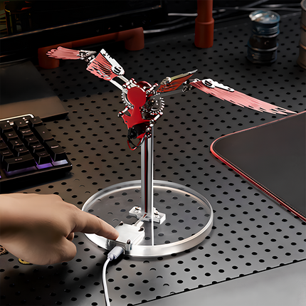 Bionic Mechanical Bird 3D Puzzle Metal Kit - A captivating DIY toy for mechanics and tech enthusiasts, this self-assembled piece showcases a bionic mechanical bird with red metallic wings, featuring electronic components for kinetic movement. Placed on a desk, it serves as a table funny decor, embodying the fusion of bionic engineering and mechanical art, inviting you to craft a dynamic and visually striking piece of bio-mechanical artistry with precision and innovative sensibility.