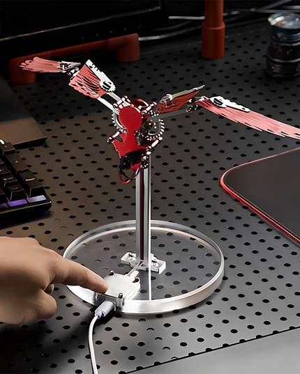 Bionic Mechanical Bird 3D Puzzle Metal Kit - A captivating DIY toy for mechanics and tech enthusiasts, this self-assembled piece showcases a bionic mechanical bird with red metallic wings, featuring electronic components for kinetic movement. Placed on a desk, it serves as a table funny decor, embodying the fusion of bionic engineering and mechanical art, inviting you to craft a dynamic and visually striking piece of bio-mechanical artistry with precision and innovative sensibility.