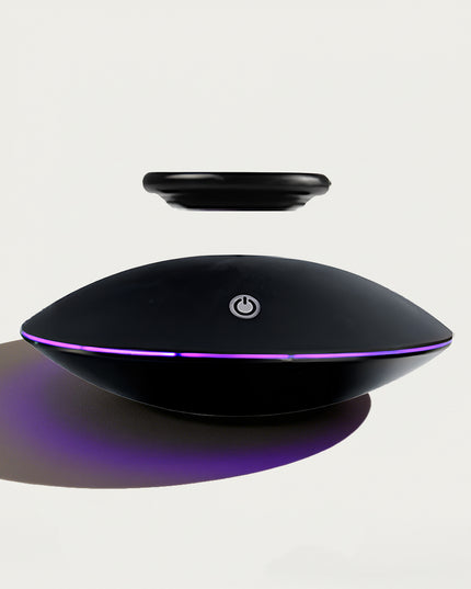 Table Funny Magnetic Levitation Decorative Piece - An innovative creation for tech enthusiasts, design admirers, and novelty decor lovers, this piece from Table Funny features a magnetic levitation decor with a sleek black UFO-shaped base, vibrant purple accent lighting, and a minimalist floating component design. Highlighted by its floating object silhouette, magnetic levitation technology, futuristic aesthetic, and subtle functional detailing (like the power button)