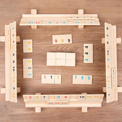 Overhead view of a Rummikub-style tile game set up on a wooden funny table surface, showcasing number tiles and racks. Ideal for strategy game enthusiasts and family gatherings.