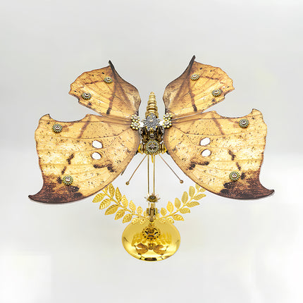 A magnificent frontal view of a steampunk puzzle, a mechanical butterfly with wide, naturalistic brown and yellow patterned wings and an intricate gold and silver mechanical body, prominently displayed on a gleaming golden stand against a clean background. This symmetrical metal model highlights sophisticated mechanical steampunk design, making it an impressive 3D puzzle Metal Kit for hobbyists or a striking steampunk mech display piece that showcases its unique coloration and detailed craftsmanship.