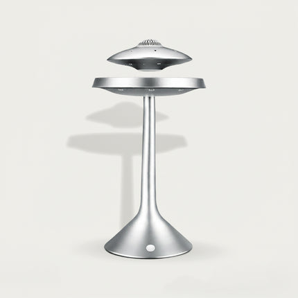 Table Funny Magnetic Levitation UFO Decor Piece - A sleek sci-fi decor item for design enthusiasts, futurism fans, and home decor lovers, this is Table Funny’s magnetic levitation UFO-themed piece. It features a matte silver metallic structure, a floating UFO-shaped top (with vent-like details), a suspended mid-platform, and a curved stand base (with integrated magnetic components), paired with a minimalist futuristic aesthetic