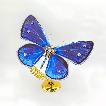 A majestic steampunk puzzle, a mechanical butterfly with wide, vibrant blue and purple wings adorned with sparkling accents, elegantly poised on a golden stand against a clean background. This intricate metal model highlights sophisticated mechanical steampunk design, making it an impressive 3D puzzle Metal Kit for hobbyists or a captivating steampunk mech decorative piece that showcases its luminous coloration and detailed craftsmanship from a dynamic angle.