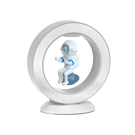 White magnetic levitation desktop display, featuring an astronaut model suspended within a ring floating atop a matching-color base — magnetic levitation ornament