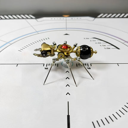Side view of a meticulously crafted steampunk ant 3D puzzle metal kit on a white measurement grid, featuring a glossy black abdomen, a golden head, and intricate mechanical steampunk legs and pincers.