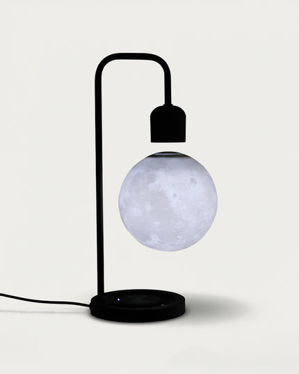 Table Funny Magnetic Levitation Moon Lamp Artwork - An innovative creation for astronomy lovers, interior design enthusiasts, and tech admirers, this piece from Table Funny features a magnetic levitation moon lamp with a sleek black metal stand, a realistic lunar surface replication, and a minimalist design. Highlighted by its floating celestial sphere silhouette, magnetic levitation technology, accurate lunar texture detailing, and modern monochromatic design