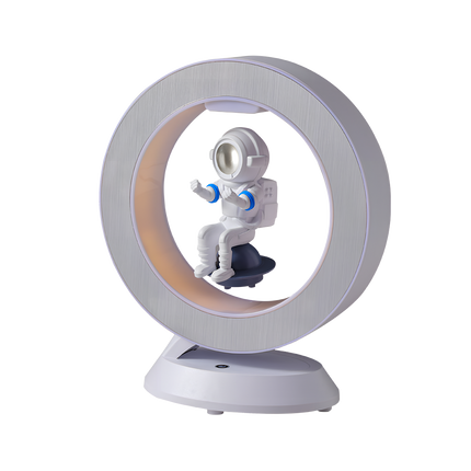 Floating astronaut figurine inside a brushed metal LED halo ring lamp on a white magnetic levitation base—modern anti-gravity desktop and night light décor.