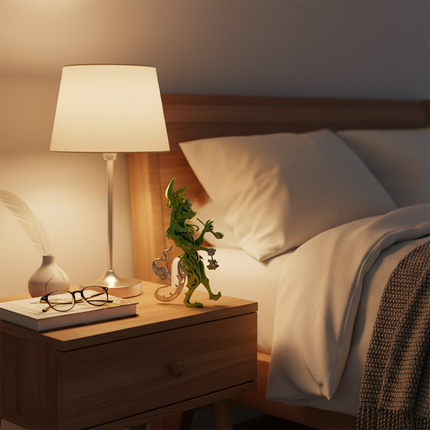 A whimsical green DIY 3D puzzle metal kit metal model, charmingly displayed on the nightstand alongside a warm-toned lamp, creates a cozy evening ambiance. This playful metal model serves as a unique and amusing tabletop decoration, perfect for adding a touch of whimsy to any bedroom or personal space