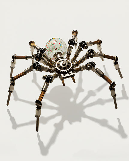 Table Funny 3D Puzzle Metal Kits Spider-Form Artwork - A unique eclectic creation for DIY enthusiasts, industrial/mechanical design lovers, and decor admirers, this piece from Table Funny is an elaborate spider-form artwork assembled from 3D puzzle metal kits. It features a silver-brass metallic structure paired with a colorful confetti glass spherical core, articulated multi-jointed legs (with copper-wrapped segments), and exposed gear mechanics