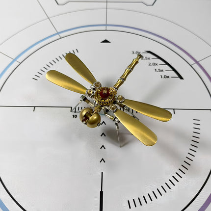  Elegant steampunk dragonfly 3D puzzle metal kit on a white measurement background, featuring four lustrous golden wings and a detailed mechanical steampunk body with a red accent.