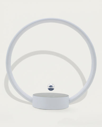 Table Funny Magnetic Levitation Minimalist Decor - An innovative creation for design enthusiasts, tech lovers, and minimalist decor admirers, this piece from Table Funny features a magnetic levitation decor with a light gray circular frame, subtle ambient lighting, and a tiny metallic floating sphere. Highlighted by its floating minimalist silhouette, magnetic levitation technology, clean lines, and soft monochromatic design