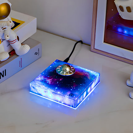 Magnetic levitation UFO model displayed on a desk with space-themed decor, creating a futuristic and inspiring atmosphere