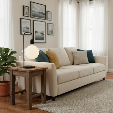 Magnetic levitation spherical table lamp with a black curved stand, placed on a wooden side table—providing warm bedside and living room ambient lighting for minimalist-style homes.