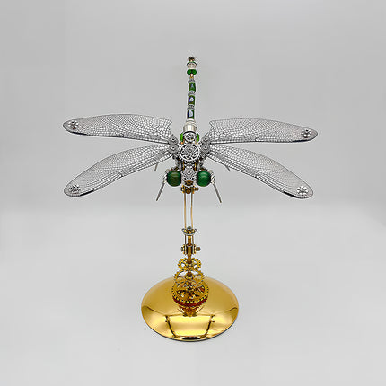 A sophisticated steampunk puzzle, a towering mechanical dragonfly with intricate silver-toned wings and a slender green and silver body, elegantly poised upright on a gleaming golden stand against a clean background. This exquisite metal model showcases advanced mechanical steampunk design, making it an impressive 3D puzzle Metal Kit for enthusiasts or a striking steampunk mech centerpiece that embodies precision and elegant artistry.