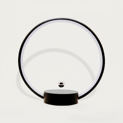 Table Funny Magnetic Levitation Minimalist Decor - An innovative creation for design enthusiasts, tech lovers, and minimalist decor admirers, this piece from Table Funny features a magnetic levitation decor with a black circular frame, subtle ambient lighting, and a tiny metallic floating sphere. Highlighted by its floating minimalist silhouette, magnetic levitation technology, clean lines, and modern monochromatic design