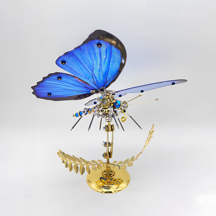 Side view of a magnificent blue butterfly metal model, showcasing its detailed mechanical body and vibrant blue wings on a golden decorative base. An exquisite example of a metal model kit, perfect for collectors of metal 3D puzzles.