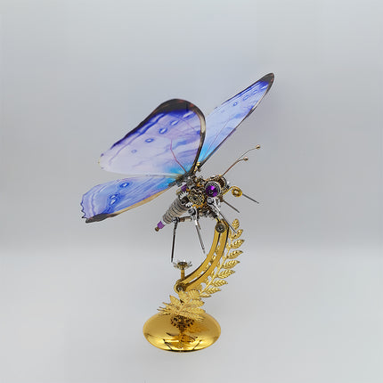 This is a Tablefunny steampunk mechanical butterfly 3D metal puzzle kit: Made of metal, it replicates the butterfly’s form, featuring transparent wings with blue-purple gradient paired with mechanical components like gears and axles (plus purple decorative details), and a golden fern-shaped base—it’s a creatively designed decorative 3D metal model toy.