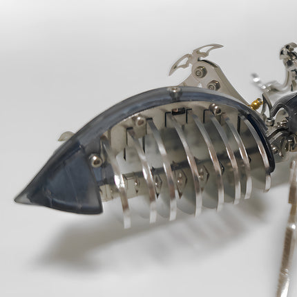 Extreme close-up of the mechanical ant model showing layered metal ribs and translucent abdominal shell design.