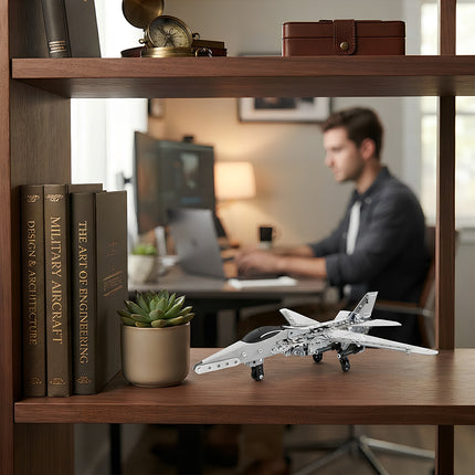 A sleek 3D metal mechanical fighter jet aircraft model displayed on a wooden bookshelf in a modern home office setting.