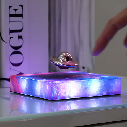 Magnetic levitation UFO model floating above a starry base, a stylish and futuristic desk ornament