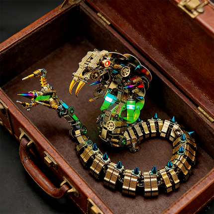 Close-up of a meticulously crafted mechanical steampunk cobra metal model, nestled inside an open vintage leather suitcase. This detailed 3D puzzle showcases intricate gears and vibrant accents, making it a unique steampunk puzzle and part of premium metal kits.