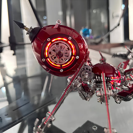 Close-up of a red mechanical spider metal model's core component, featuring an illuminated gear and intricate mechanical steampunk details. This 3D puzzle metal kit offers unique glowing elements for a captivating steampunk puzzle.