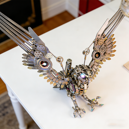  A magnificent steampunk mech sea eagle maquette en metal with wings spread, featuring intricate gears and iridescent accents. This striking 3D metal model kit is proudly displayed on a white table, serving as a captivating steampunk puzzle and decorative piece.