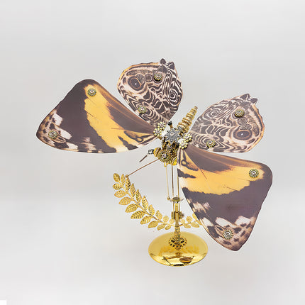 A magnificent frontal view of a steampunk puzzle, a mechanical butterfly with wide, distinctive brown and yellow patterned wings and an intricate gold and silver mechanical body, prominently displayed on a gleaming golden stand against a clean background. This symmetrical metal model highlights sophisticated mechanical steampunk design, making it an impressive 3D puzzle Metal Kit for hobbyists or a striking steampunk mech display piece that showcases its unique coloration and detailed craftsmanship.