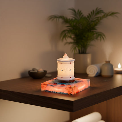 Magnetic levitation Zen lamp rests atop a magnetic levitation base, placed on a dark wood spa table surface, flanked by rolled towels and decorative bowls — modern ambient lighting and home/spa decor