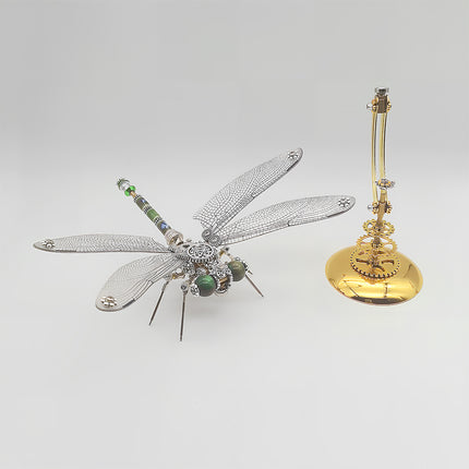 This shows the disassembled/assembled state of Tablefunny’s steampunk dragonfly 3D metal puzzle: On the left is the fully assembled dragonfly (made of silver and gold-toned metal, with wings replicating fine textures, green accents on the head, and steampunk elements like gears on the body); on the right is the matching golden stand base (featuring steampunk gear details). The design retains the dragonfly’s agile form, and the piece offers decorative appeal—suitable as a desktop ornament or creative gift.