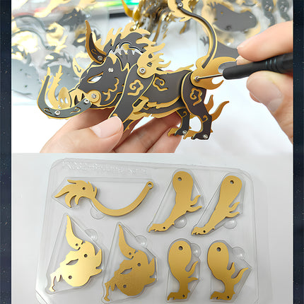 Hands assembling a black and gold 'Dangkang' stylized boar metal model 3D puzzle, with a tray of unpunched golden parts below, illustrating the engaging mechanical steampunk puzzle building process for this Metal Kits.