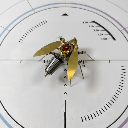 A completed steam punk mech fly model, viewed from the front, highlighting its symmetrical design, golden accents, and intricate metal kit components.