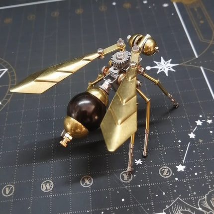 A detailed golden and bronze mechanical wasp 3D puzzle metal model, an exquisite DIY metal kit, with articulated wings and visible gears, placed on a dark, star-themed mat. This metal model is a charming and funny table ornament, ideal for steampunk enthusiasts.