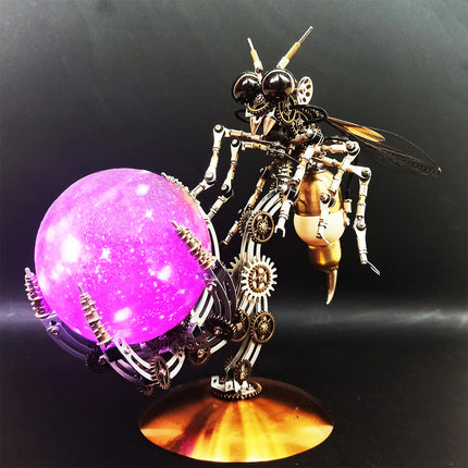 Striking display of a mechanical steampunk wasp metal model 3D puzzle Metal Kit with bronze wings and intricate gears, posed next to a decorative stand holding a glowing purple celestial sphere. This impressive steam punk mech and its illuminated steampunk puzzle accessory create a unique visual.