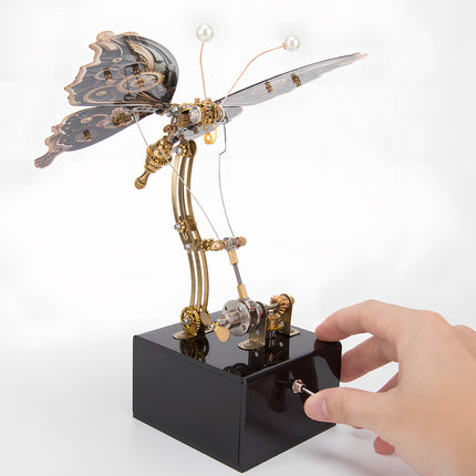 Hand activating a steampunk butterfly metal model, an interactive funny table display. This DIY 3D puzzle metal kit offers a tactile and engaging experience, bringing the model to life."