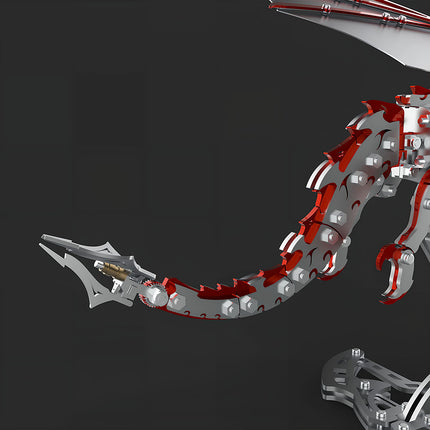  Close-up of the metal model dragon's tail, featuring striking red and silver mechanical steampunk scales and an intricate articulated design. This detailed 3D puzzle metal kit offers unique components for a steampunk puzzle.