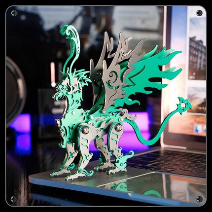 Green mythical griffin metal model standing on a laptop, an intricate mechanical steampunk creature from our 3D puzzle Metal Kits.