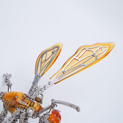 Close-up of translucent amber wings with metallic veins on a metal insect model kit, highlighting craftsmanship.