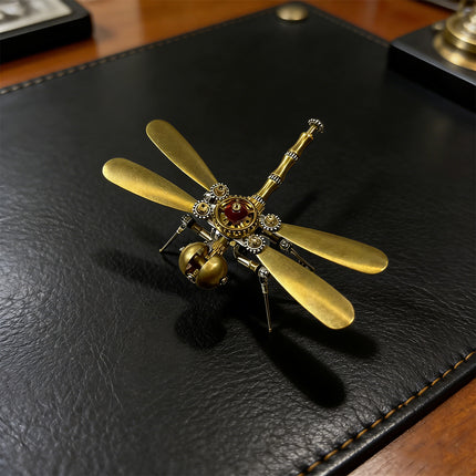  A meticulously crafted brass dragonfly metal model, featuring golden wings and steampunk-inspired gears, resting on a dark leather surface. This exquisite 3d puzzle metal model makes for a unique funny table or desk ornament.
