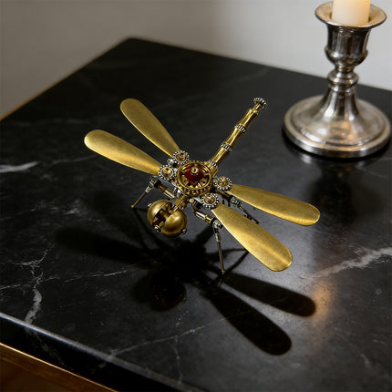  A stunning brass dragonfly metal model, with golden wings and intricate clockwork details, displayed as a sophisticated funny table decoration on a polished black marble surface. This 3d puzzle metal kits creation adds elegance to any space.

