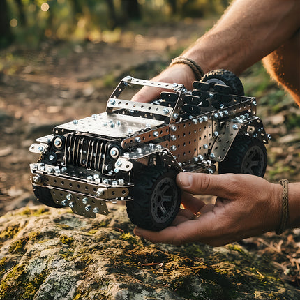 Assembled DIY metallic off-road vehicle puzzle kit featuring rugged rubber tires held outdoors.