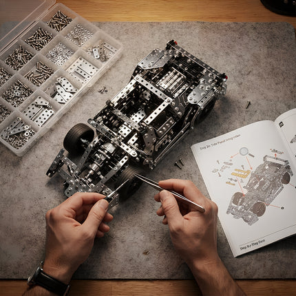 Close-up of metal sports car puzzle components, organization tray, manual, and precision tools during building.