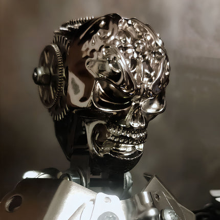 Shiny metal skull head with gears, part of a mechanical steampunk metal model. This detailed steampunk puzzle is a centerpiece of a 3D puzzle metal kit.