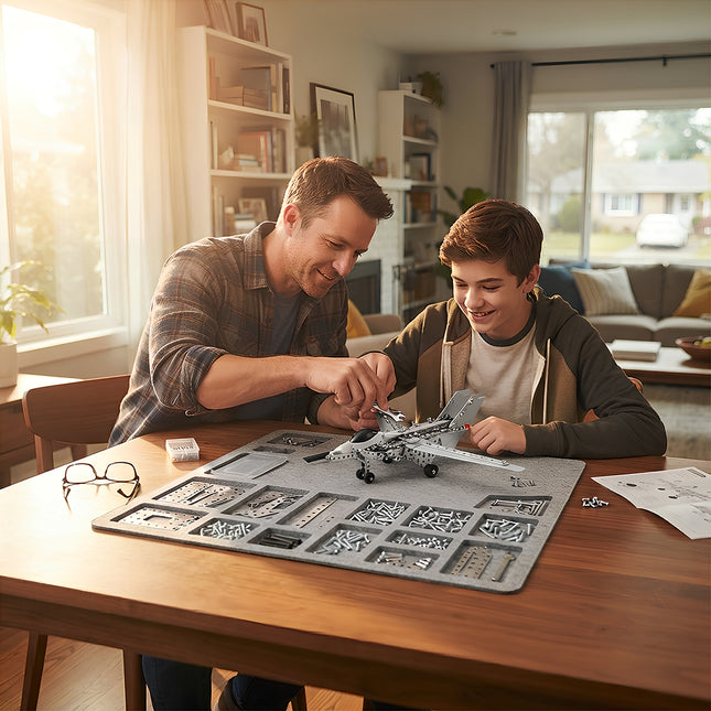 A smiling father and son assembling a 3D metal mechanical fighter jet model kit together at a sunny dining table.