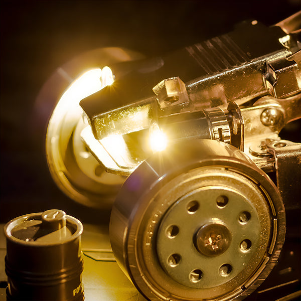 Close-up of a glowing LED headlight and realistic wheel on a steam punk mech metal model built from 3D puzzle metal kits.