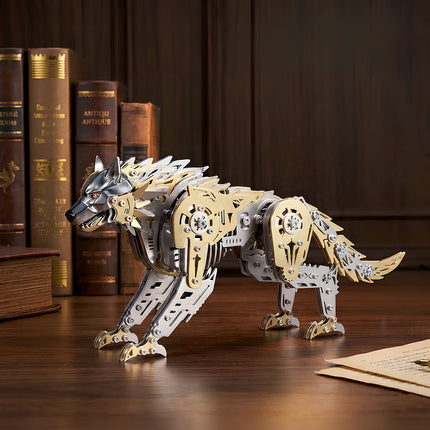 An assembled gold and silver 3D metal mechanical wolf model displayed on a dark wooden desk in front of vintage books.