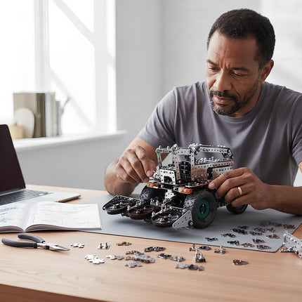 A focused adult man carefully assembling a 3D metallic combine harvester model kit at a modern bright desk.