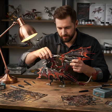 A craftsman carefully using pliers to assemble a red and black 3D metal mechanical dragon model at a workbench under a lamp.
